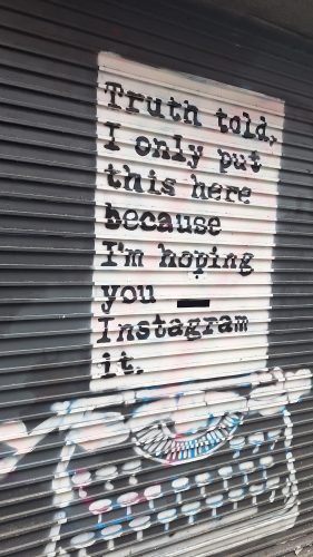 Street art on metal shutters with text Truth told, I only put this here because I'm hoping you Instagram it
